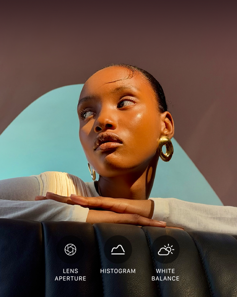Close-up portrait of a well-lit model with a colourful background, demonstrating the Pro camera system's Pro controls UI: Aperture, Histogram, White Balance